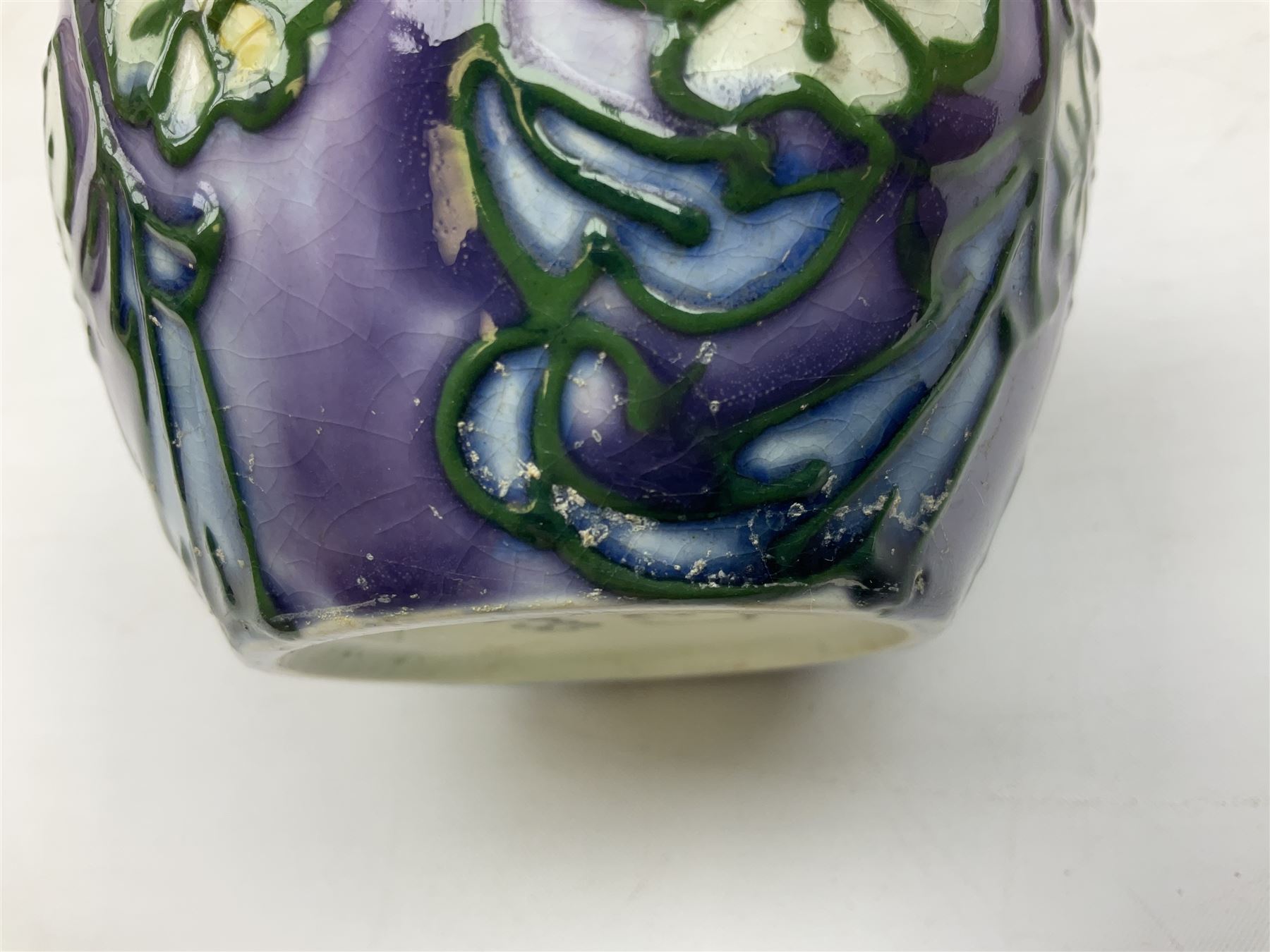 Three Minton Secessionist vases, with tube-lined stylised flower decoration, two upon a red ground and third upon a purple ground, all with printed mark to base 'Minton Ltd, No. 33', H13cm