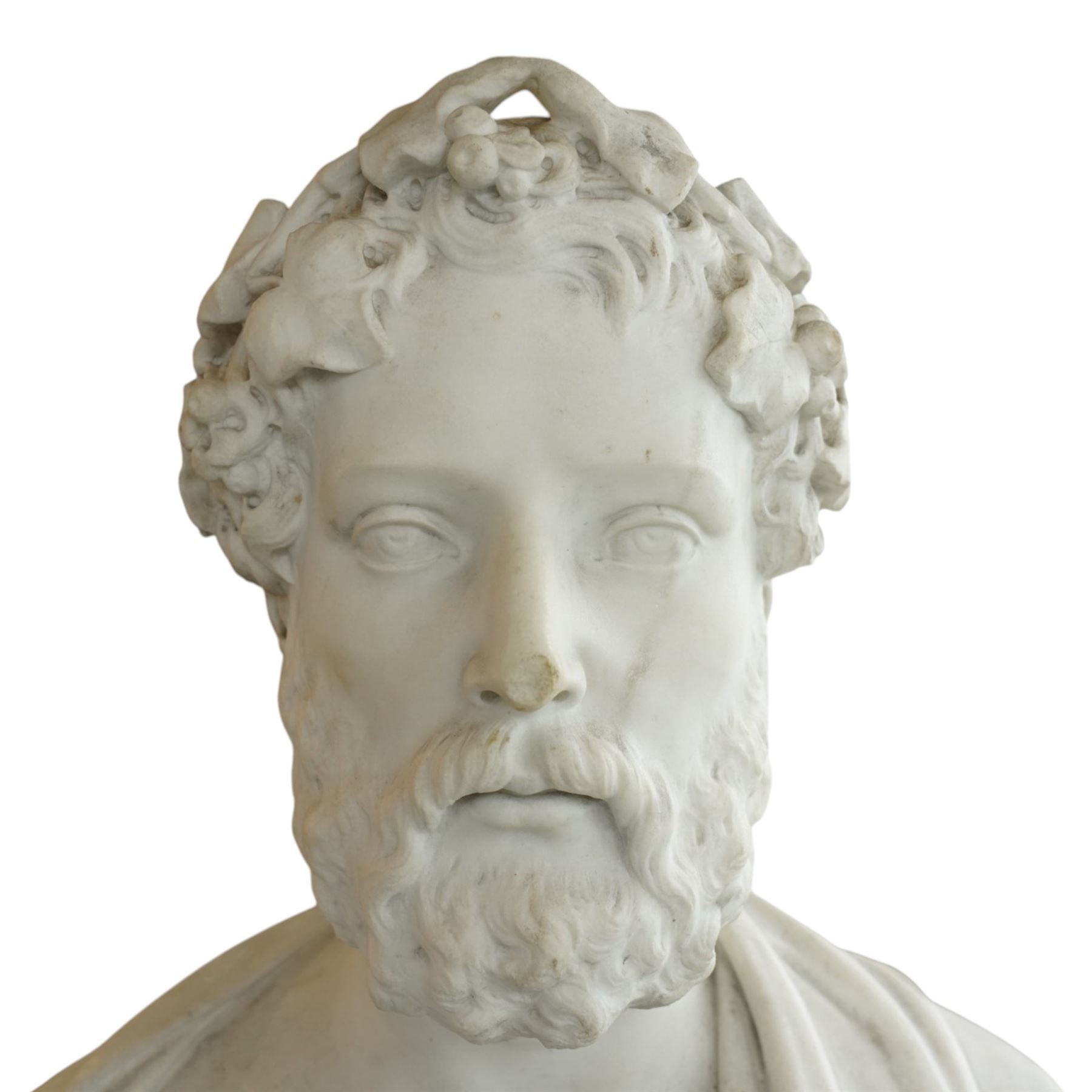 Aristide Louis Fontana (Italian 1834-1907): Grand Tour marble bust of a Roman emperor, probably inspired by portraits of Marcus Aurelius, portrayed with finely carved curled hair and beard beneath a grapevine wreath with trailing vine leaves and clusters of fruit, the draped shoulders and truncated chest raised upon a turned circular socle, signed to the reverse, H61cm; together with the associated faux marble pedestal of rectangular form, H94cm
Provenance: Kirkham Hall