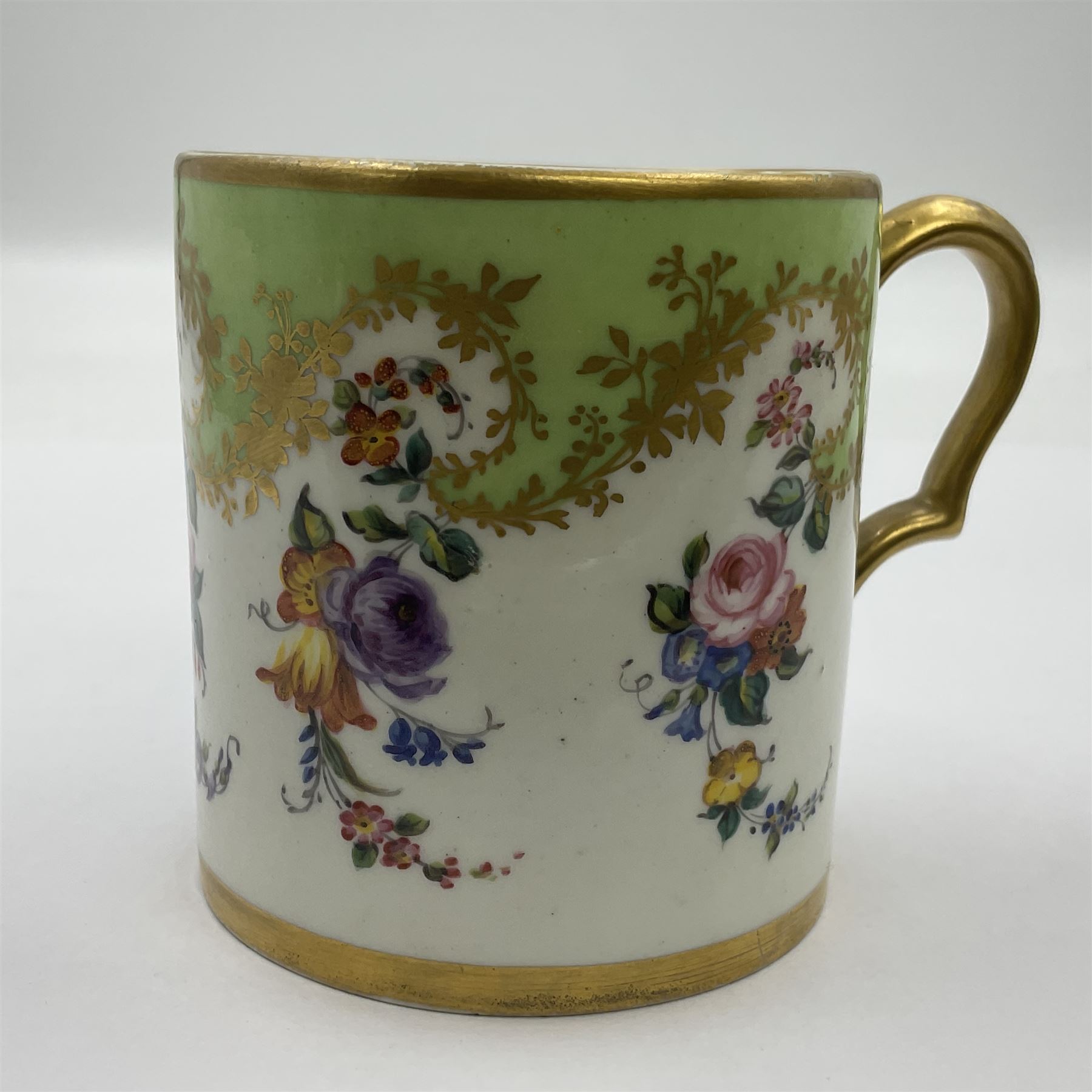 Sèvres soft paste porcelain coffee can and saucer with date code for 1754, painted and gilded with flowers, dangling from the shaped green border, interlaced LL monogram enclosing the date letter A above painters mark for Dodin, coffee can H7cm, saucer D14.5cm