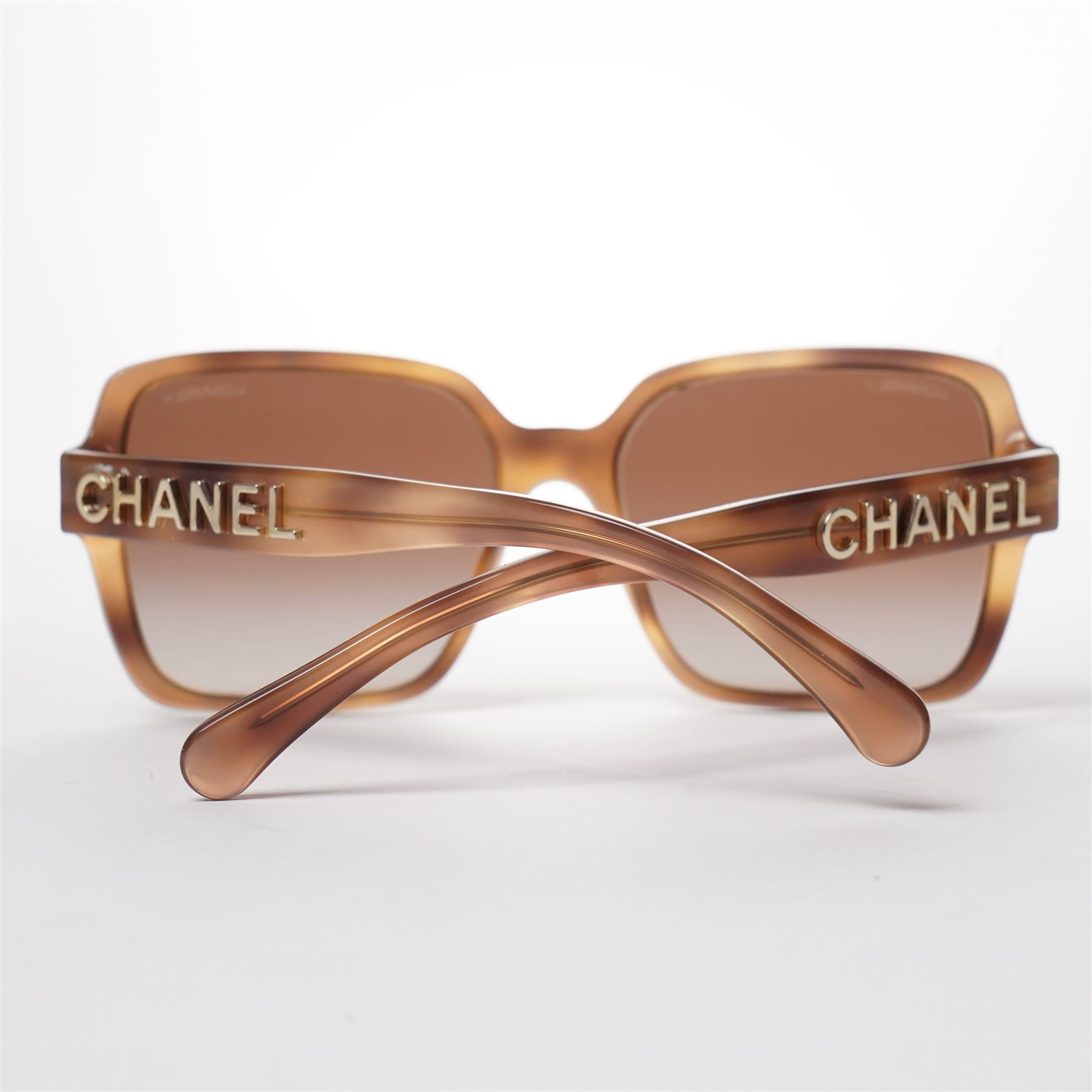 Chanel - pair of oversized sunglasses, with translucent tortoiseshell-effect brown acetate frames and gradient tinted lenses, the arms boldly set with gold-tone ‘CHANEL’ lettering, with original quilted leather case, booklet and box