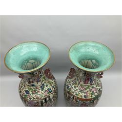Pair of large 19th century Chinese Famille Rose porcelain vases, each of baluster form with twin zoomorphic handles, decorated in enamels with panels of lively court scenes, against a ground painted with blossoming flowers, fruiting vines, birds, grasshoppers and butterflies, between ruyi and key borders, H60cm

