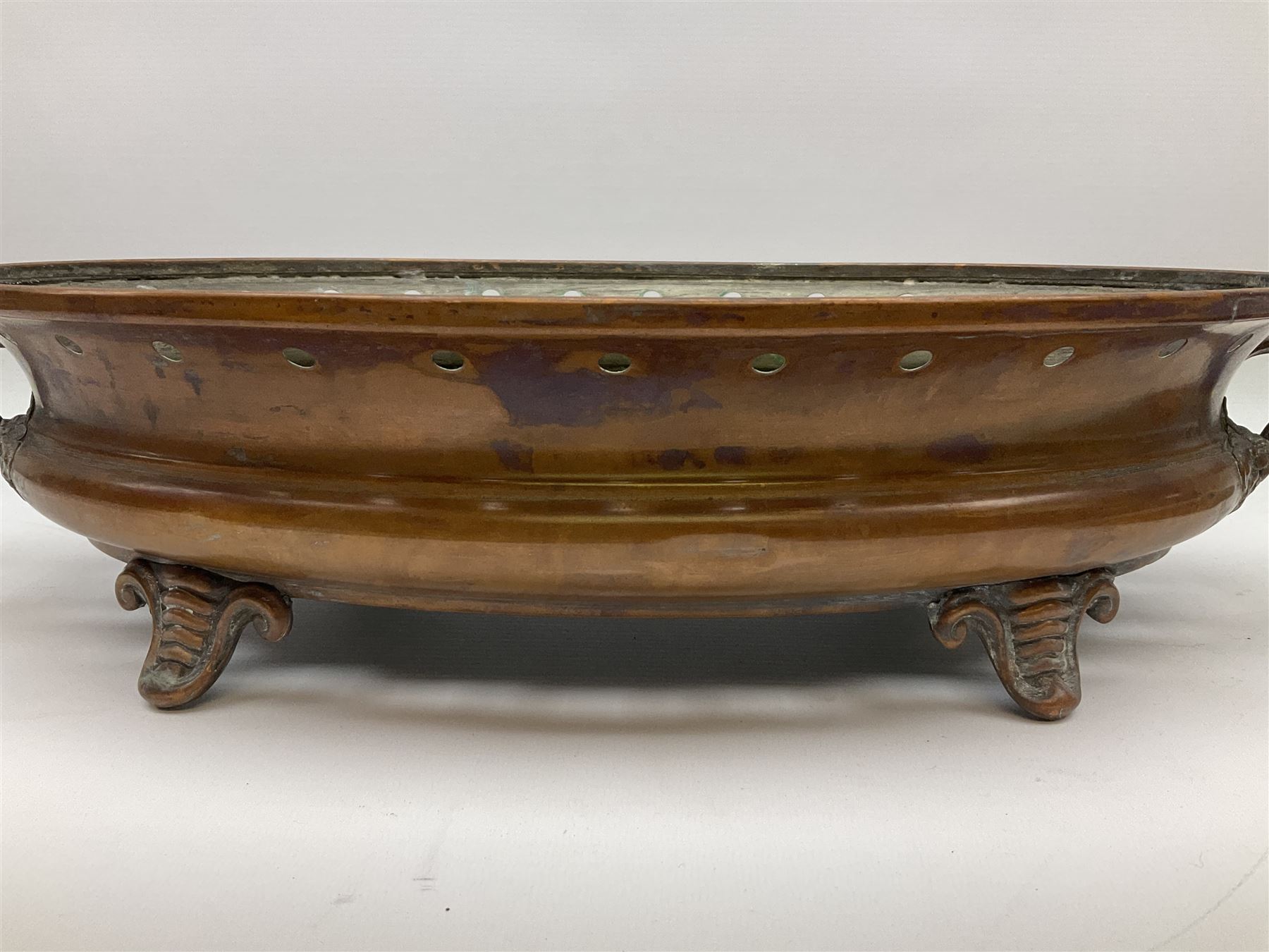 Agricultural copper corn funnel, H32.5cm, another similar copper funnel and copper warming platter of oval form, with twin handles on four supports, with removeable warming plate, L49cm