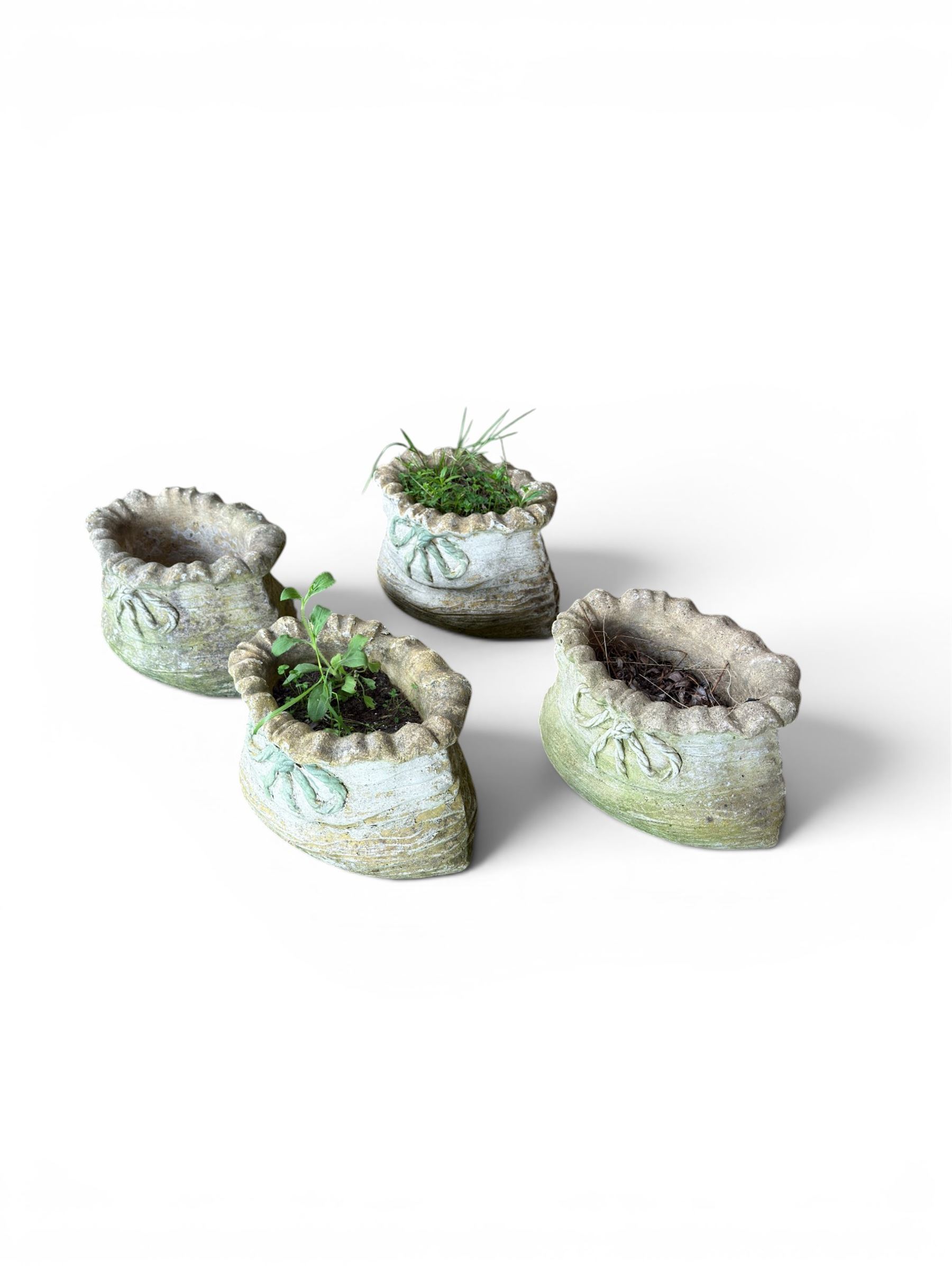 Four cast stone garden planters in the form of ribbon tied planting sacks