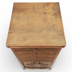 20th century French style oak bedside chest of pedestal form, the top with rounded moulded edge with drop leaf to the back, above five carved drawers with applied scroll ornament and turned knobs, the cupboard base with twin carved doors with diamond lattice panels, with shaped apron and bracket feet