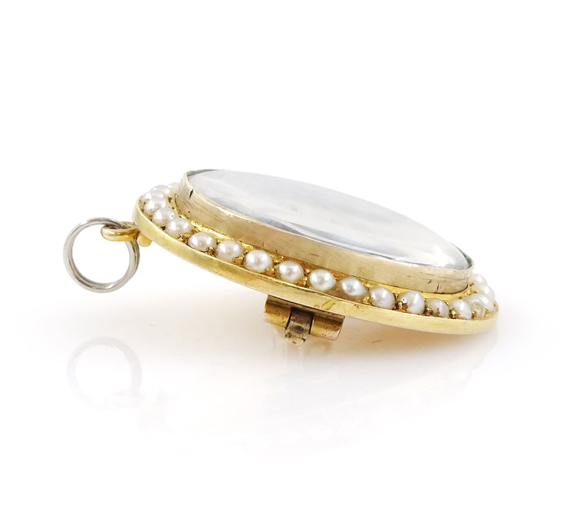 19th century 9ct gold seed pearl brooch/ pendant, set with an oval miniature of a woman, on ivory, under a glazed panel, with a seed pearl surround. This lot has been registered for sale under Section 10 of the APHA Ivory Act