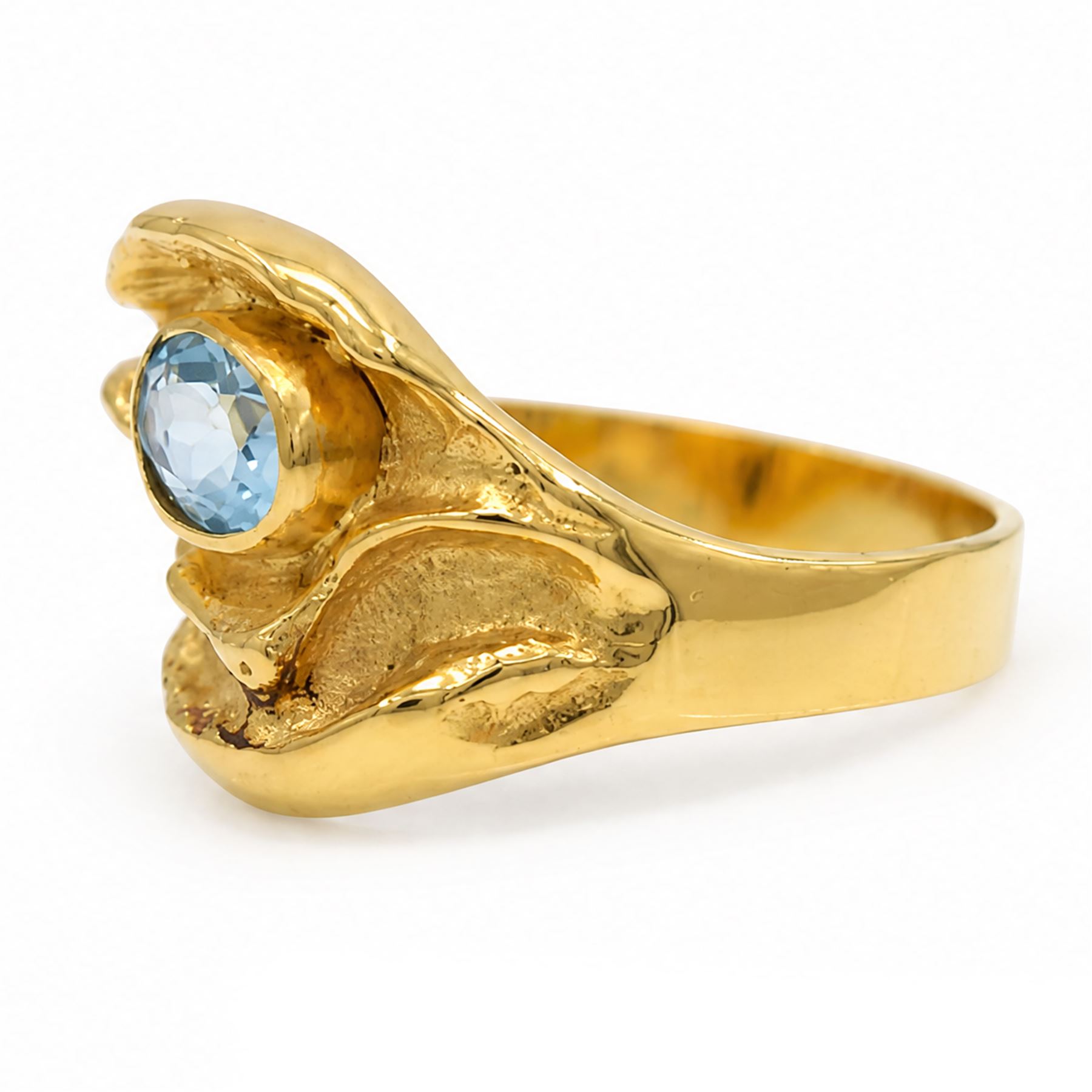 18ct gold Swiss blue topaz ring, bezel single oval cut topaz, within an abstract creased design setting, stamped 750