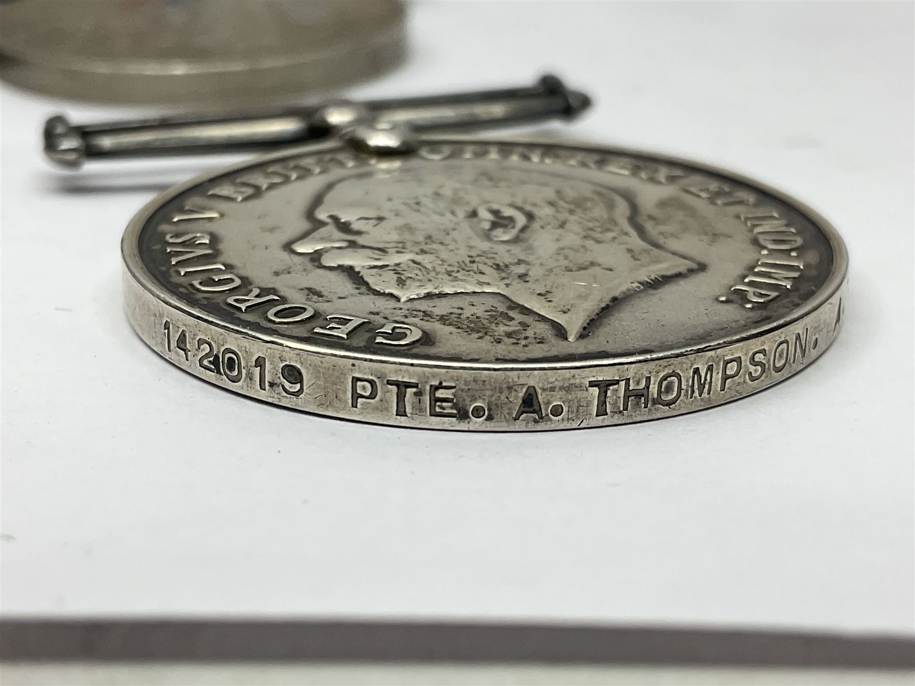 WWII group of five medals comprising 1939-45 War Medal, Defence Medal, 1939-45 Star, Africa Star and France and Germany Star on wearing bar; WWI British War Medal awarded to 142019 Pte. A. Thompson A.S.C.; and boxed King's Badge 'For Loyal Service'