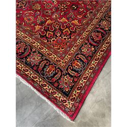 Persian Meshed carpet, red ground with central rosette medallion surrounded by interlacing foliage and stylised flower heads, repeating border with signature panel 