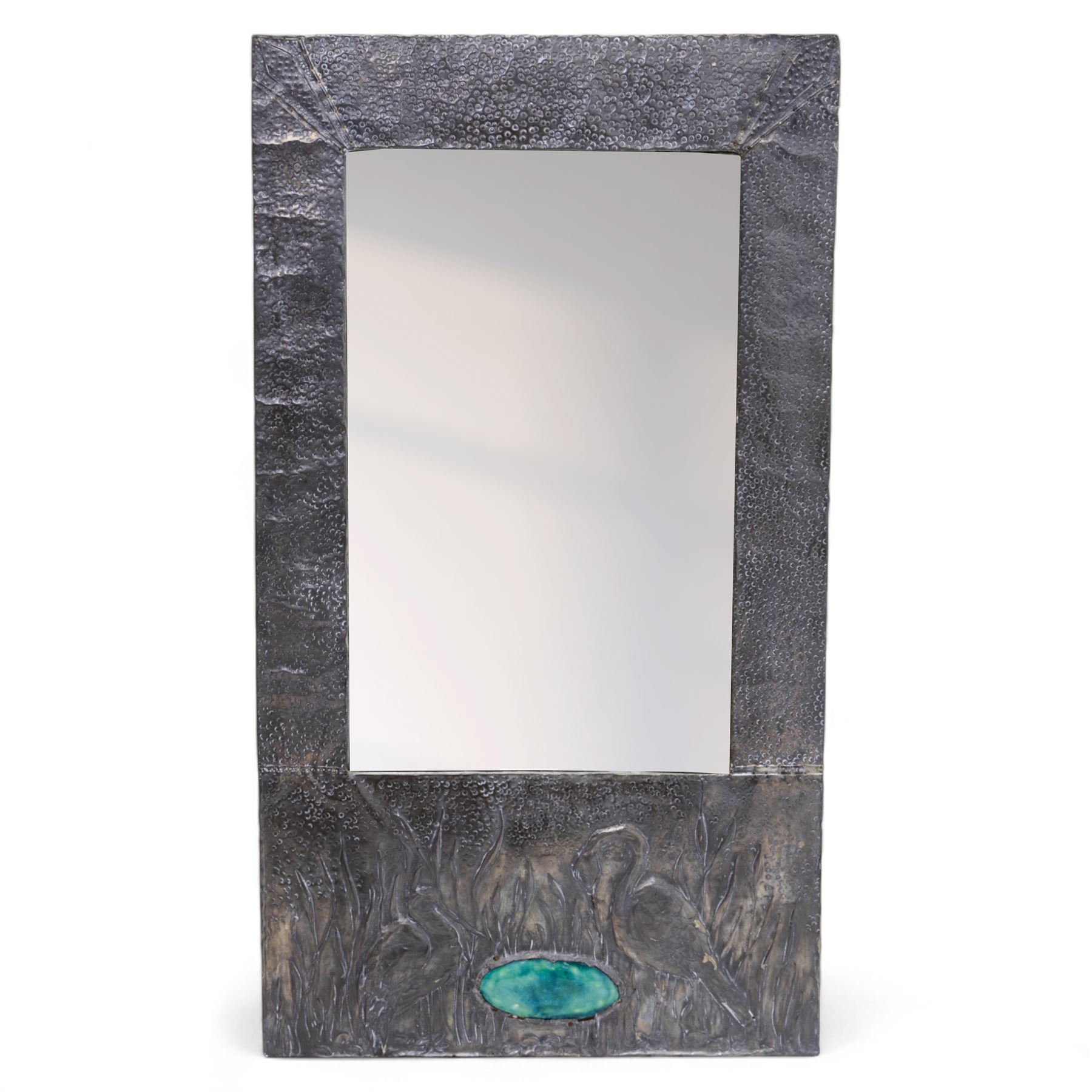 Early 20th-century Arts and Crafts pewter wall mirror, rectangular bevelled mirror plate within a punched pewter frame repoussé decorated with herons among reeds, with a central inset green enamel cabochon panel