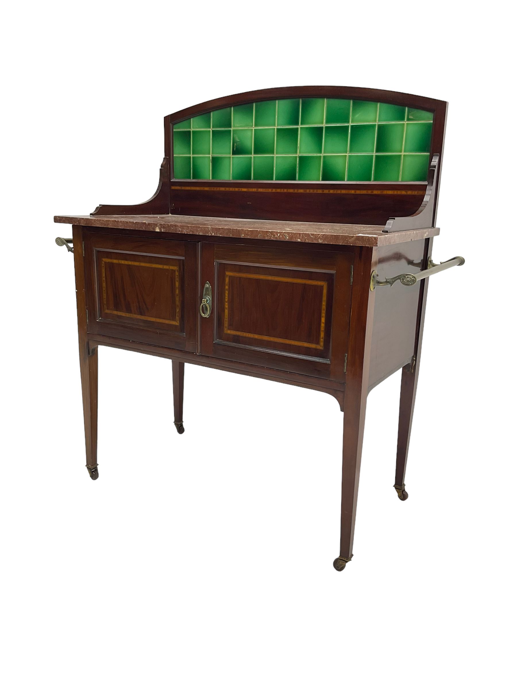 Edwardian inlaid mahogany washstand, raised back with emerald green tiles over marble top, fitted with two panelled cupboard doors, raised on square tapering supports on ceramic castors