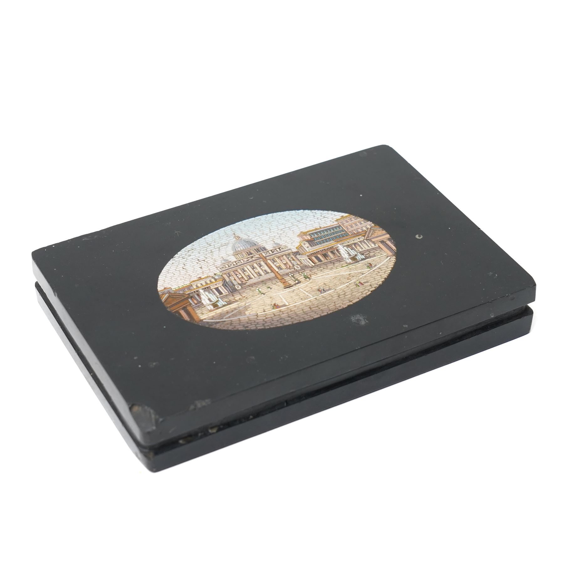 19th-century Italian Grand Tour micromosaic paperweight, the rectangular slab of polished Nero Belgio black marble inset with an oval micromosaic panel finely composed in minute tesserae, depicting a classical architectural view evocative of ancient Rome, centred by a triumphal column and flanked by monumental buildings, 14cm x 9.5cm