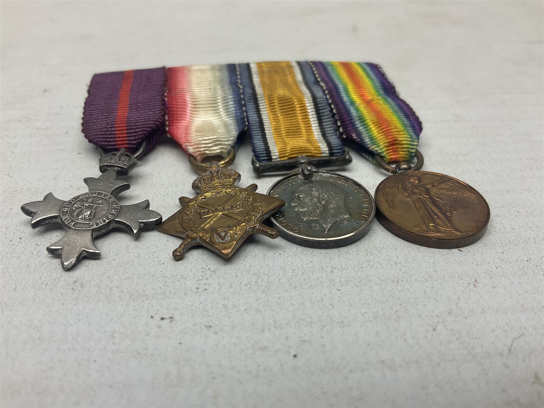 George V Military Cross miniature group of six medals comprising MC, WW1 trio including 1914 Star, Long Service and Good Conduct Medal and General Service Medal with Iraq clasp; and miniature group of four medals comprising Military OBE and WW1 trio including 1914-15 star; all with ribbons and both on pinned wearing bars