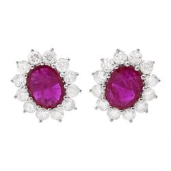 Pair of 18ct white gold oval ruby and round brilliant cut diamond cluster stud earrings, stamped 18K, total ruby weight approx 3.55 carat, total diamond weight approx 2.20 carat