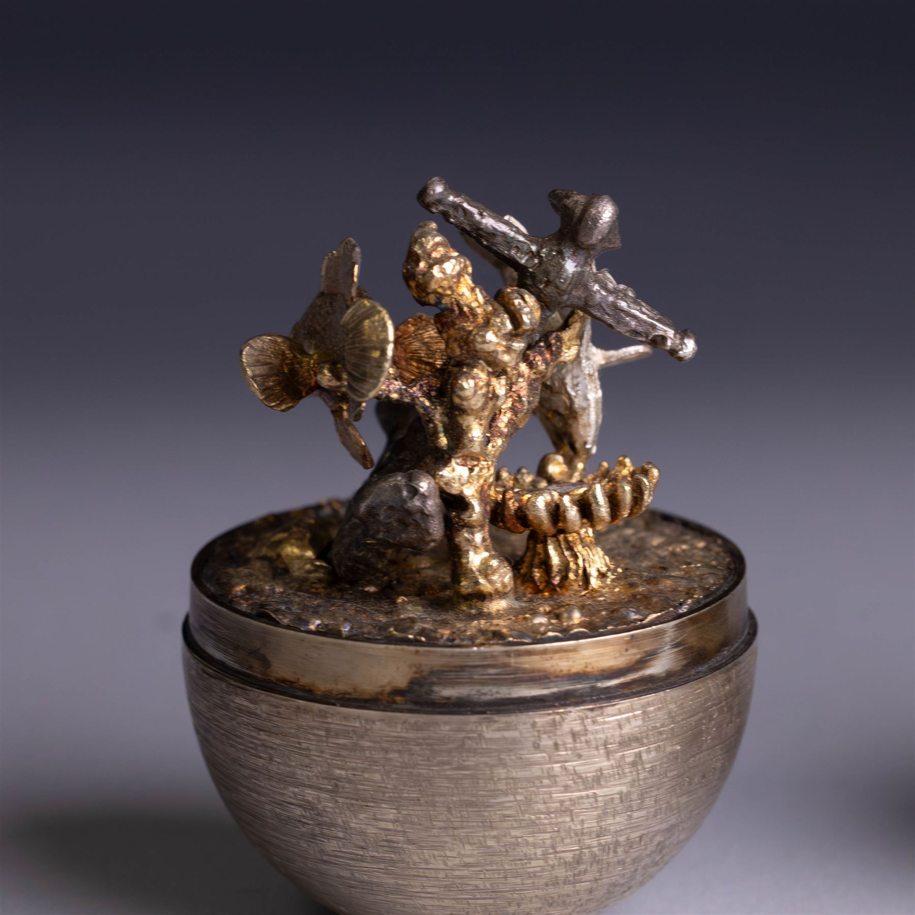 Stuart Devlin - Late 20th century silver and silver-gilt surprise egg, the textured gilt exterior opening to reveal an underwater scene with two fish and an anchor, hallmarked Stuart Devlin, London 1977, boxed, H10cm