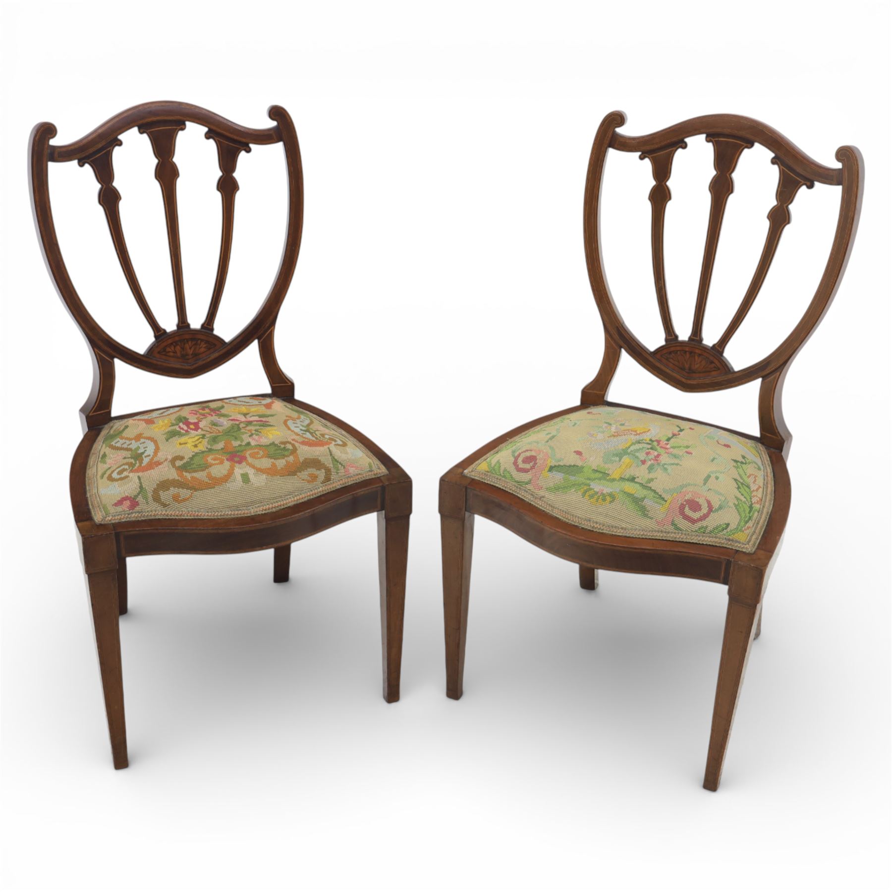 Edwardian pair of satinwood inlaid shield back chairs, the pierced shield shaped backs with central splats inlaid with floral and foliate motifs, tapestry upholstered serpentine seats, raised on square tapering supports