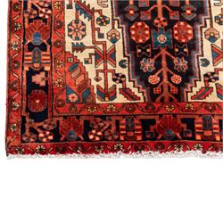 North West Persian runner, the indigo field centred by a red elongated hexagonal medallion with pendant motifs, surrounded by angular flowering stems, ivory stepped floral spandrels, enclosed by an indigo palmette border and red floral guard bands