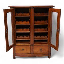Cherrywood wine rack cabinet, moulded rectangular top over two glazed doors, fitted with eight slides each with three bottle holders inscribed with various wine types, single long drawer to the base 