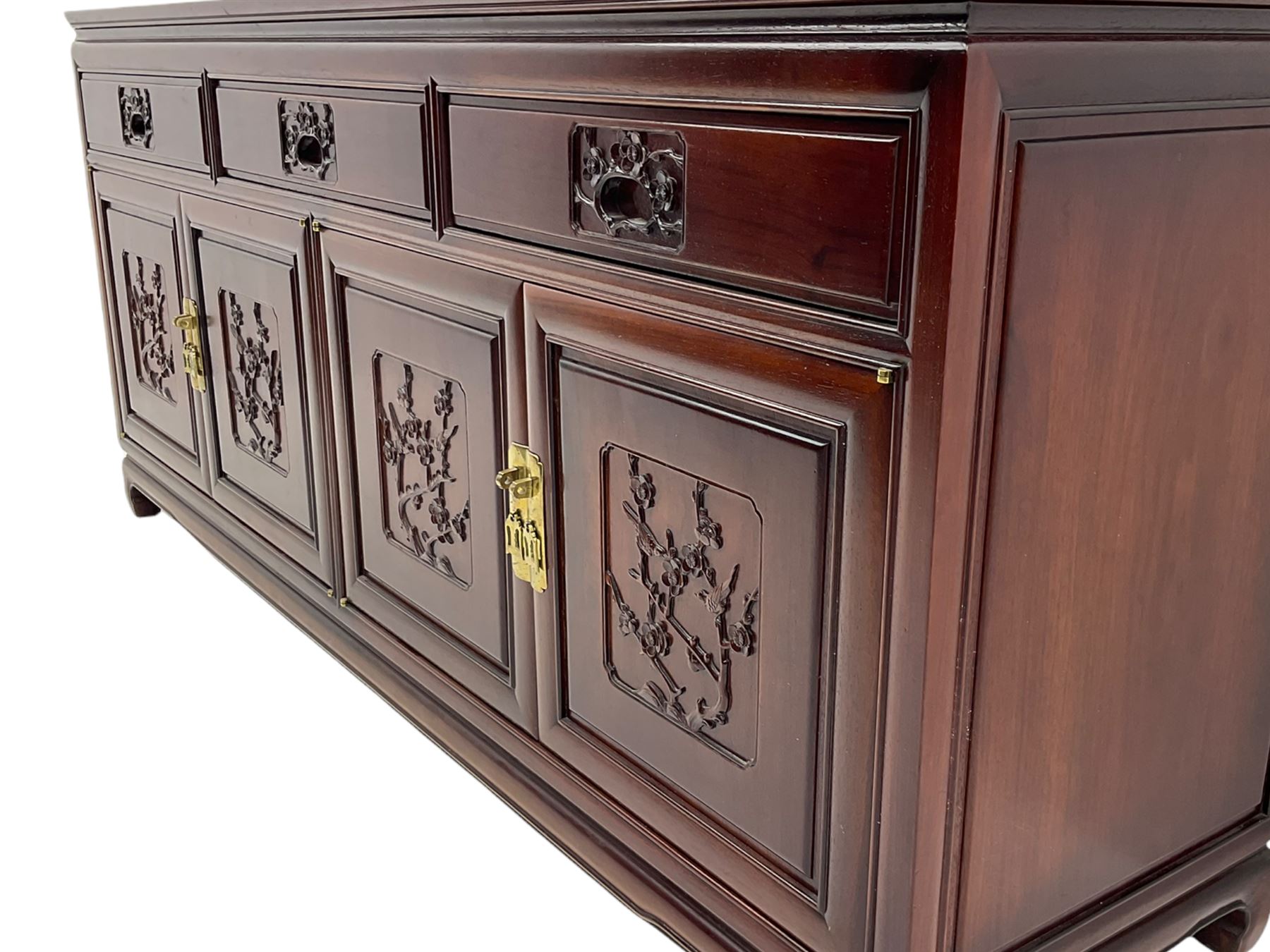 Chinese hardwood sideboard, three drawers above four cupboards, the doors relief carved with flowers and birds 