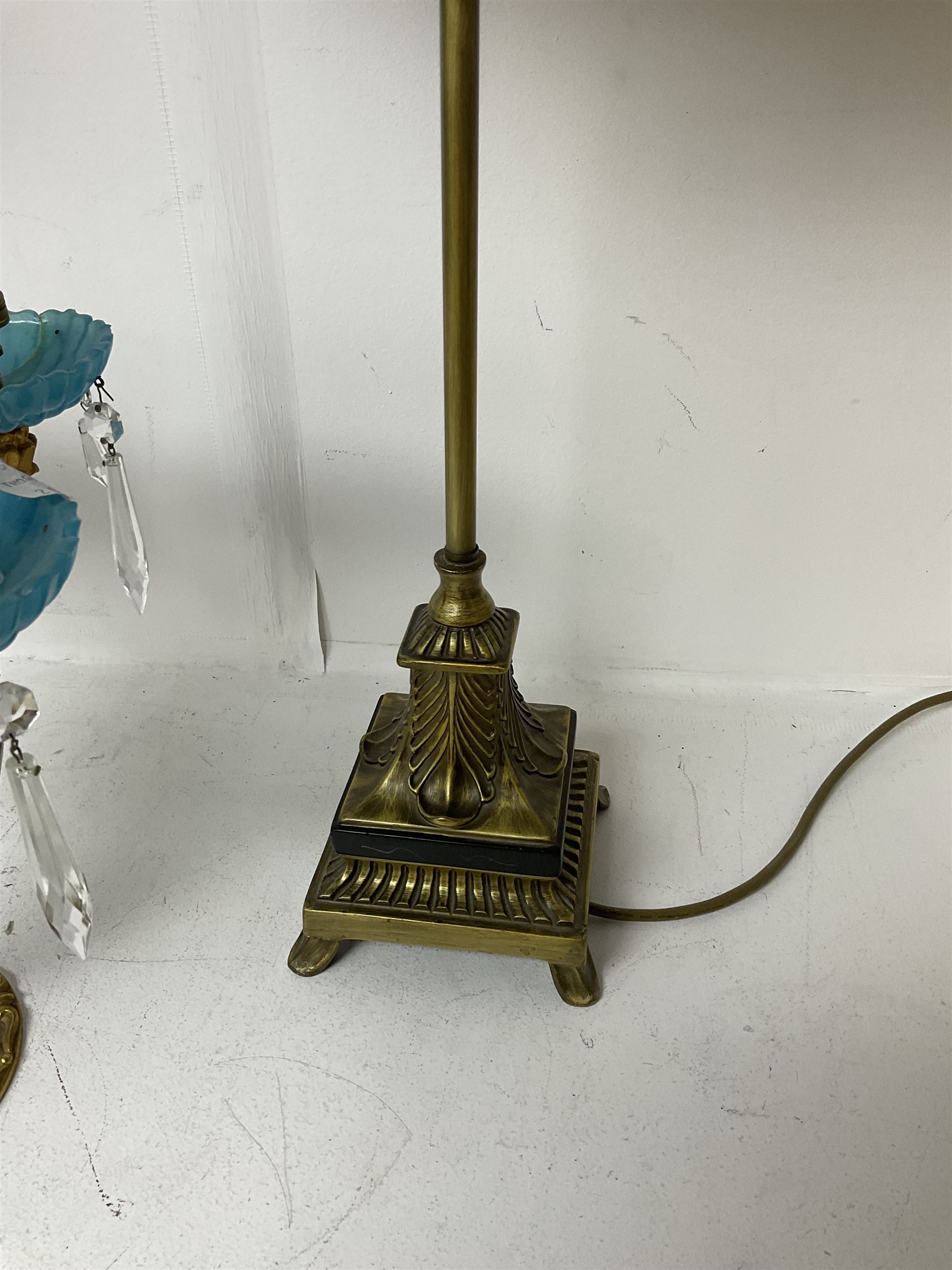 Brass table lamp, modelled as a candelabra with five branches, each with blue glass candle holders with crystal drops, H47cm, together with a pair of cast metal table lamps with acanthus leaf detail, upon a stepped square base, with red fabric feather and tassel shades, H78cm