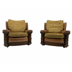 Pair of 1930’s carved oak framed club chairs, upholstered in tan studded leather with beige fabric loose cushions
