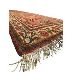 Belgian Sultan woollen ground rug, central navy field densely decorated with floral sprays and geometric patterns (192cm x 135cm); handwoven tribal terracotta ground rug (121cm x 71cm); Persian crimson ground runner, all over stylised floral and foliate motifs (266cm x 94cm)