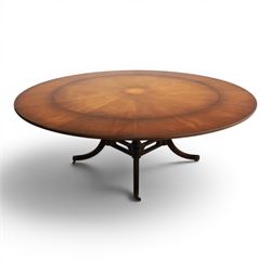 Bevan Funnell Reprodux - Regency design mahogany extending dining table, circular radial veneered top with central fan inlaid patera, on turned pedestal with four reeded downswept supports terminating in brass caps and castors, with six addtional leaves in a fitted storage case