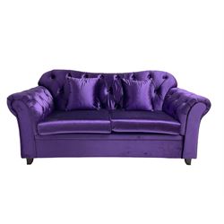 Chesterfield shaped two seat sofa, upholstered in buttoned purple fabric, with scatter cushions