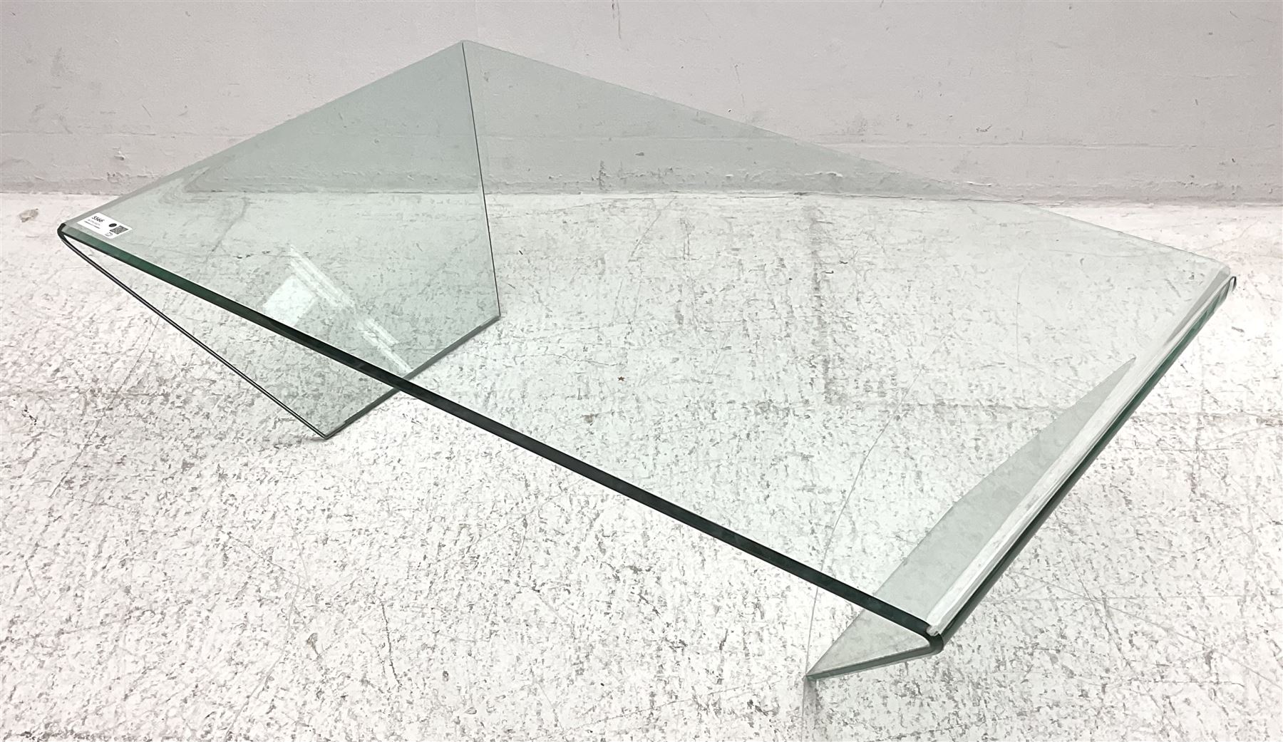 Contemporary glass coffee table, rectangular top with polished edge, on shaped end supports
