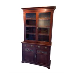 Late Victorian mahogany glazed bookcase on cupboard, projecting cornice, fitted with three shelves, base unit fitted with two long drawers and two cupboards