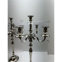 Pair of four branch candelabras, urn-shaped nozzles raised upon scroll branches supported from tapering central stem, with a stepped circular base, H59cm
