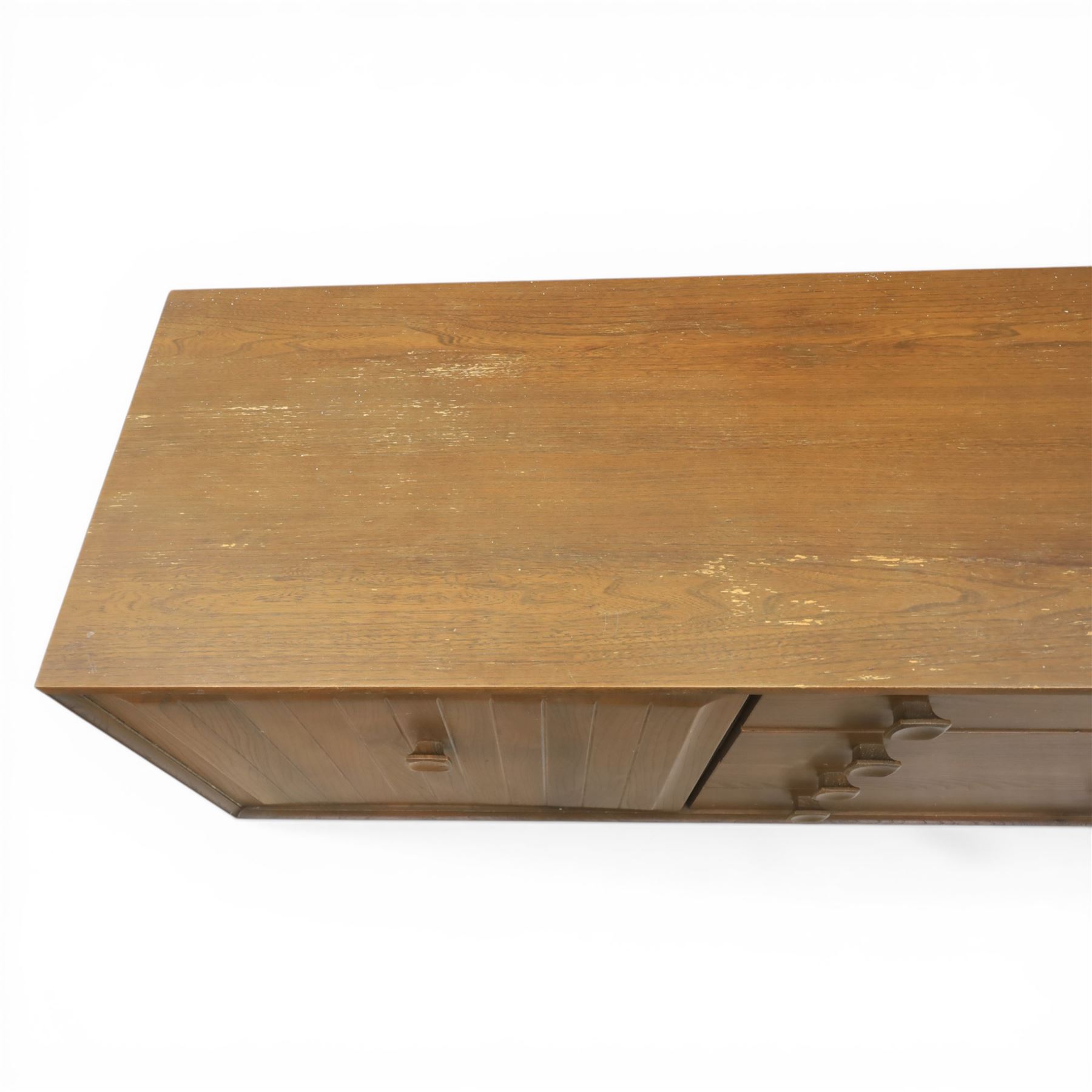 Ensign - Mid-20th century elm sideboard, with a central bank of four drawers, flanked by cupboard doors, raised on tapering supports, labelled Ensign Bristow & Townsend Ltd