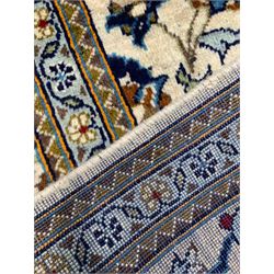 Persian Kashan ivory ground rug, the field decorated with stylised plant motifs and interlacing leafy branches, scrolling border decorated with further plant motifs, floral design guard bands  