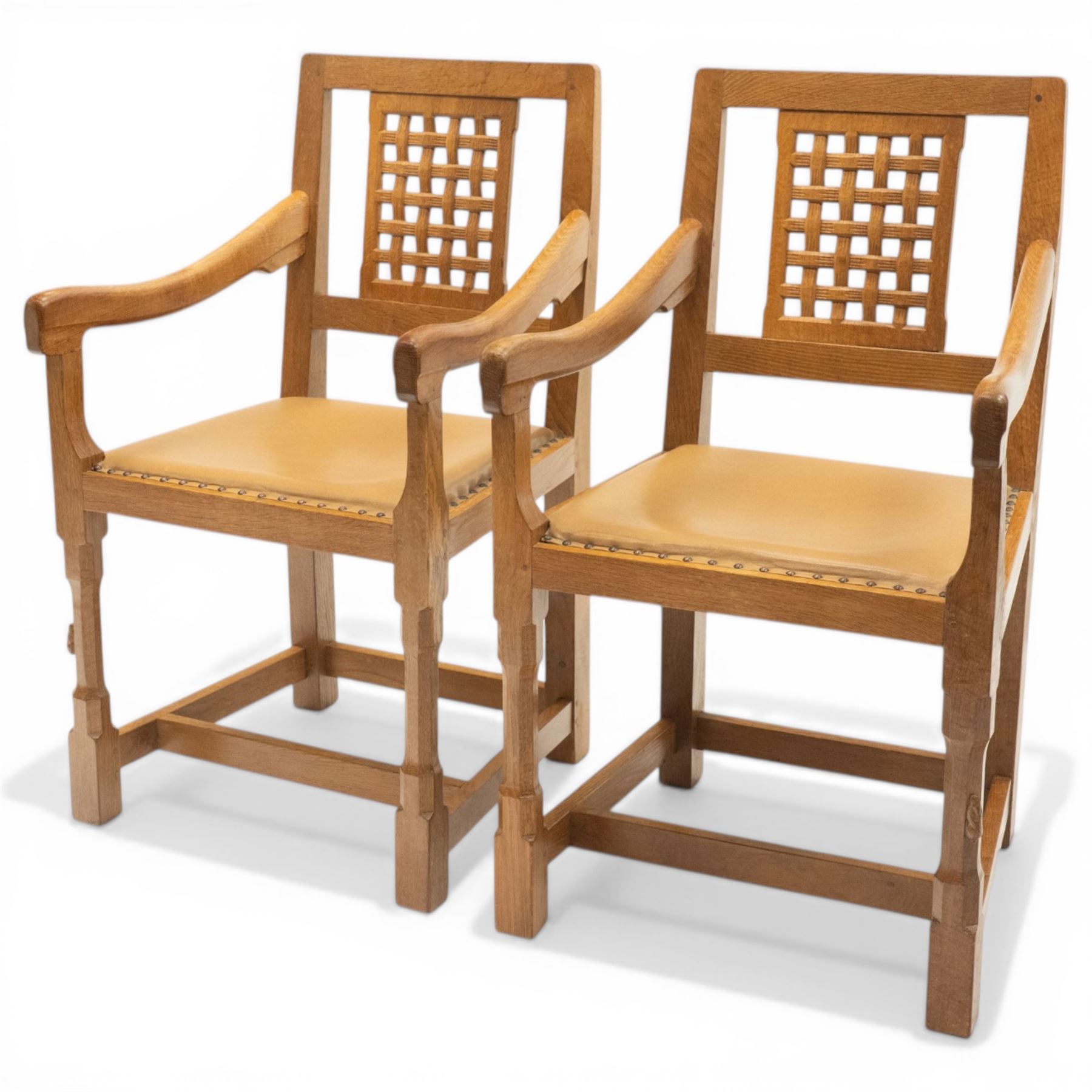 Rabbitman - pair of Yorkshire oak carver open armchairs, pierced and carved lattice back over tan leather seat with studwork, raised on octagonal supports united by H stretchers, carved with rabbit signature, by Peter Heap of Wetwang