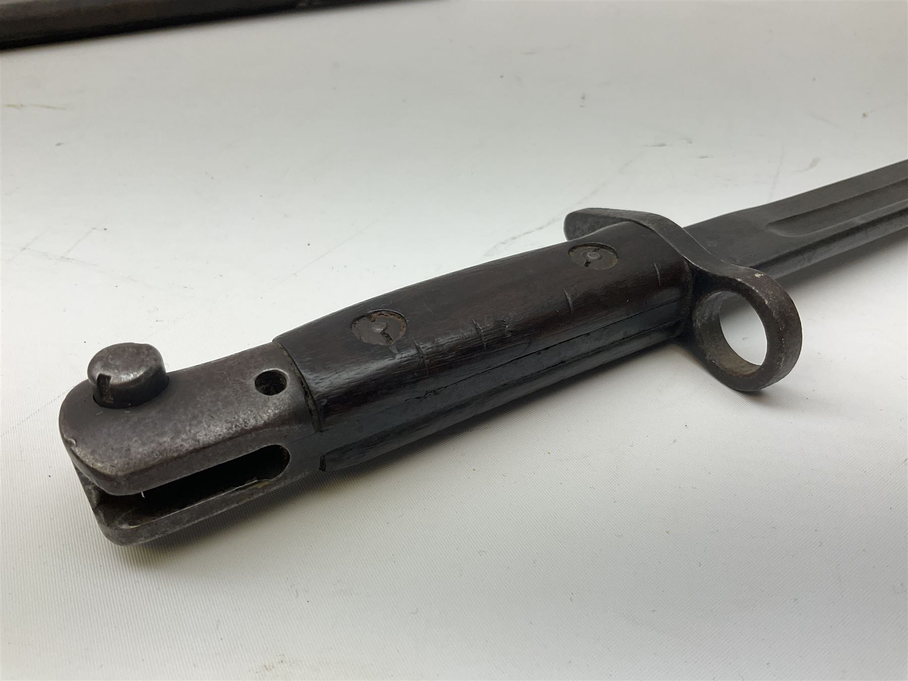 British Enfield 1907 model SMLE bayonet, with 43cm fullered steel blade and metal mounted leather scabbard L58cm overall; and Schmidt-Rubin Model 1918 bayonet the 30cm steel blade marked Elsener Schwyz No.579722; in steel scabbard with leather frog marked G. Bertolini Sellaio Vira/G.Tic 79 L45cm overall (2)