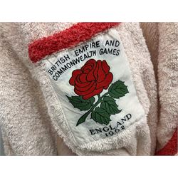 On the direct instructions of Anita Porter nee Lonsbrough Great British Olympic and Commonwealth Games gold medal winning swimmer - collection of early and international memorabilia comprising original Huddersfield Bath Club track suit top bearing eight stitched on cloth badges including British Empire & Commonwealth Games 1958 England Team, YSASA, North Eastern Counties ASA, ESSA Division 3,  English Schools Swimming Association winner etc
The swimming costume Anita wore at the 1958 Commonwealth Games in Cardiff, her first major championships, where she won two gold medals. The grey elastic on the sides, in those days, she would use to make it tighter and more streamlined.
Blue track suit from the 1960 Olympics which she wore on the podium receiving the gold medal.
1960 pool side towelling robe used at the Rome Olympics (interesting to note her name is spelt wrong on the embroidered label).
1962 Commonwealth Games pool side towelling robe used in Perth Australia when winning three Gold medals. 
It was also this year she became BBC Sports Personality of the year, the first female to do so.
Her 'lucky' pool side towel which she took with her to every event she competed in and which can be seen round her neck in many official celebratory photographs. Copies of some of these photographs are included for identification.
In addition there are two souvenir programmes of an evening event to honour Anita at The Theatre Royal Huddersfield and she has kindly signed the front cover on one of these.