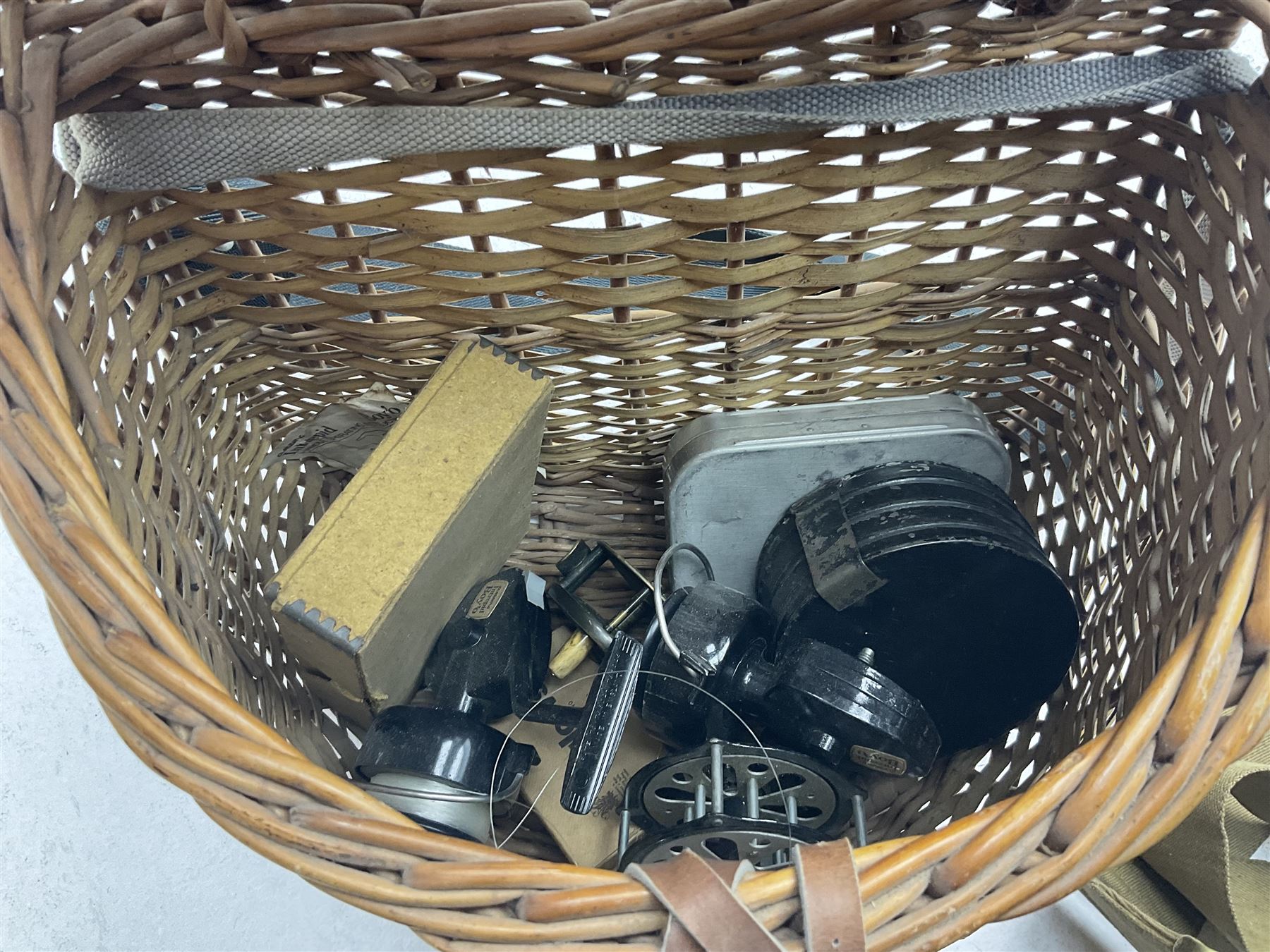 Fishing tackle and accessories housed in two wicker creels, including a landing net, fly tin, small brass reel, other reels to include two Intrepid Boy'o examples, crab lines etc 