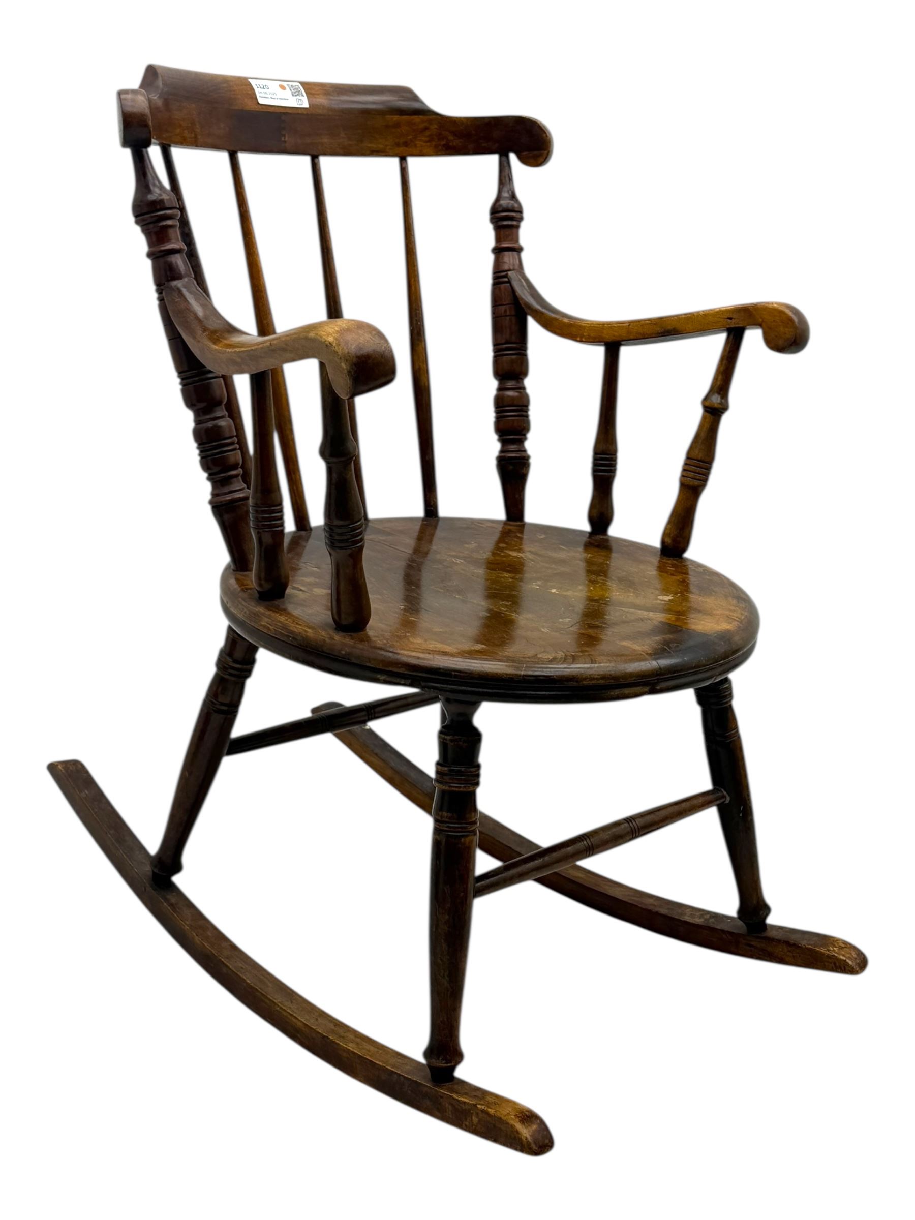 Late 19th century elm and beech Windsor rocking chair, with shaped top rail over turned spindles and curved arms, circular seat raised on turned legs united by stretcher on rockers