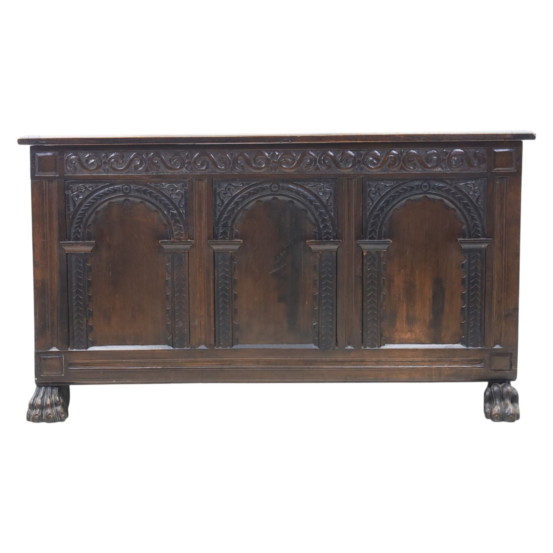 17th century design panelled oak blanket chest, hinged top above carved triple arch frieze, raised on individual carved claw feet
