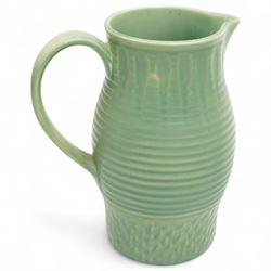 Susie Cooper pottery jug, the green glazed body with ring turned and dimpled decoration, inscribed 'Susie Cooper, England' to base, H23cm; together with two similar art deco pottery jugs with similar decoration, by Price Brothers and Ditmar Urbach, larger H21cm (3)