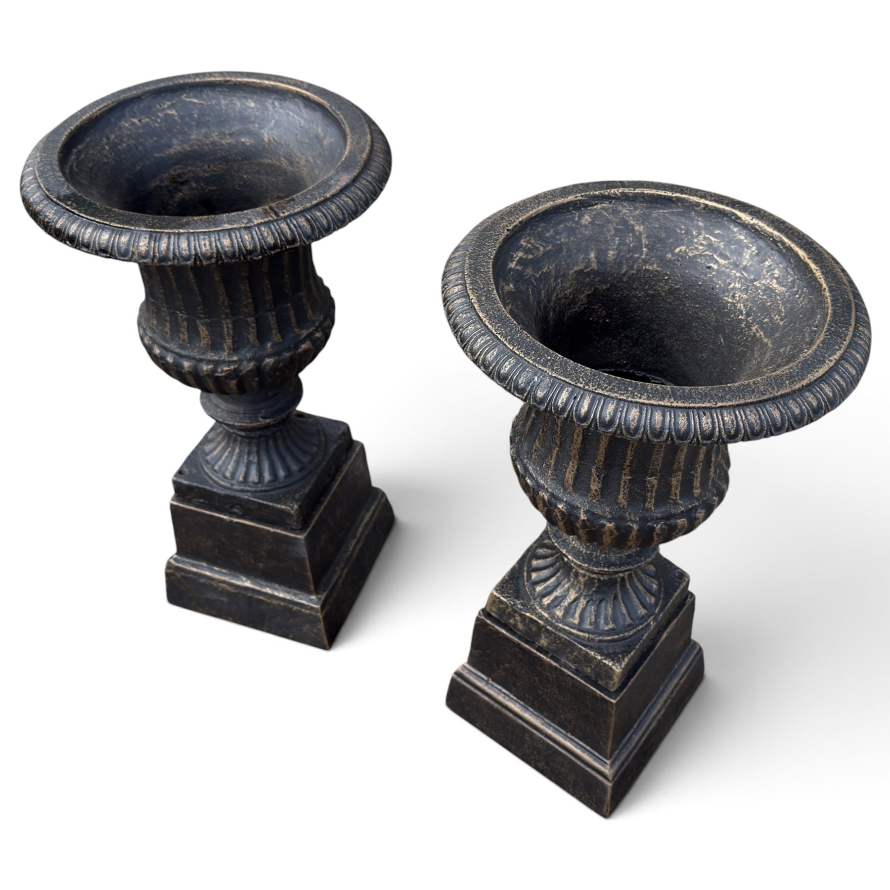 Pair of Neoclassical design black and gilt painted cast iron garden urns of campana form, with egg-and-dart rims and fluted bodies, on knopped stems, fluted socles and stepped square plinth bases