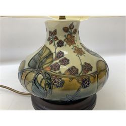 Moorcroft table lamp of squat baluster form, decorated in the Autumn Blackberry, with Moorcroft cream fabric shade with gold, green and red piping, overall H38cm