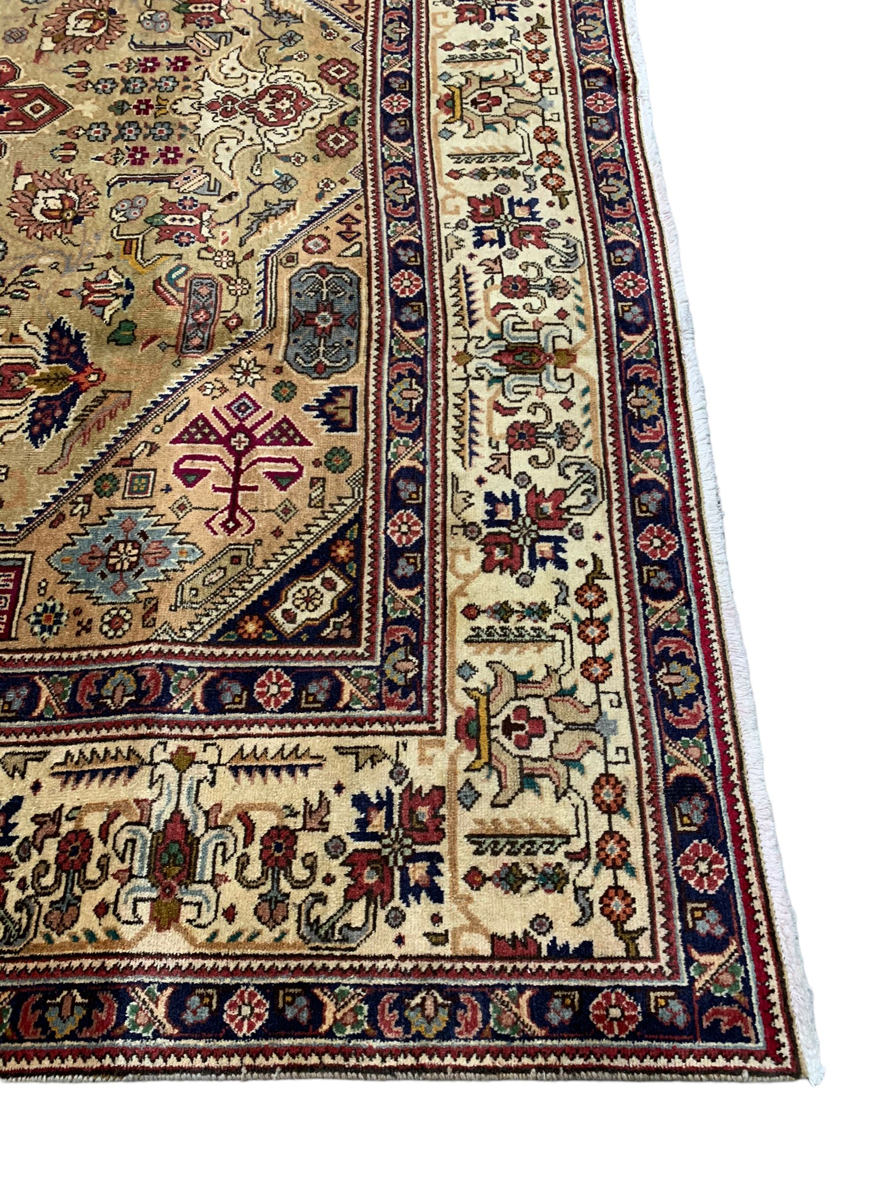 Persian Azarbaijan golden ground carpet, the shaped crimson ground medallion decorated with geometric motifs, the field profusely decorated with stylised plant and flower head motifs, repeating border with guard bands 