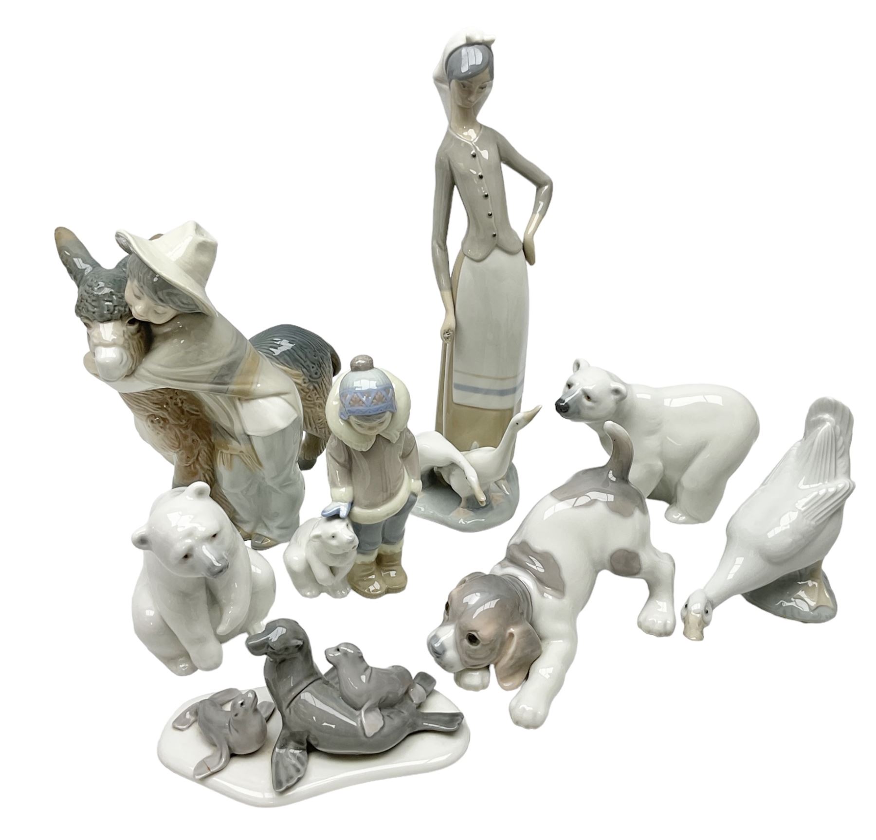 Seven Lladro figures, comprising Playful Puppy no 9135, Platero and Marcelino/Boy Hugging Donkey no 1181, Mini Seal Family no 5318, Attentive Polar Bear no 1207, Seated Polar Bear no1209, Eskimo Boy with Pet no 5238 and Girl with Geese no 1035, together with Nao goose