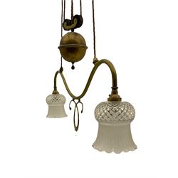 Early 20th century brass rise and fall light fitting, serpentine bar fitted with two branches, with two cut glass shades