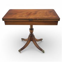 Victorian design mahogany card table, rectangular top with swivel and fold open action, revealing a baized lined interior, raised on turned baluster column, with reeded legs terminating in brass paw castors 