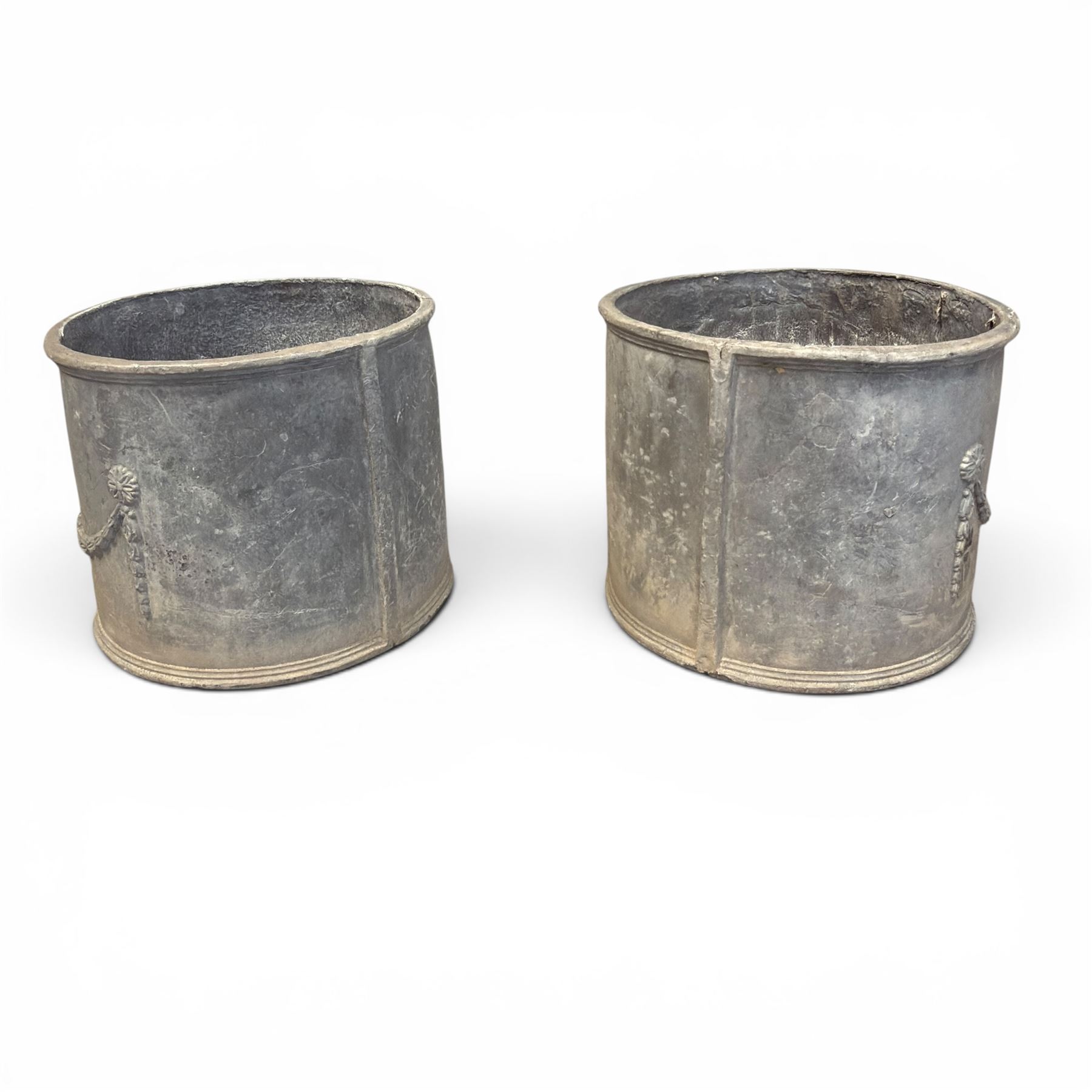 Pair of 19th century Neoclassical design lead garden planters of cylindrical form, the body decorated with an ornate central urn with swags and foliate design, flanked by festoons of bellflowers with roundel motifs