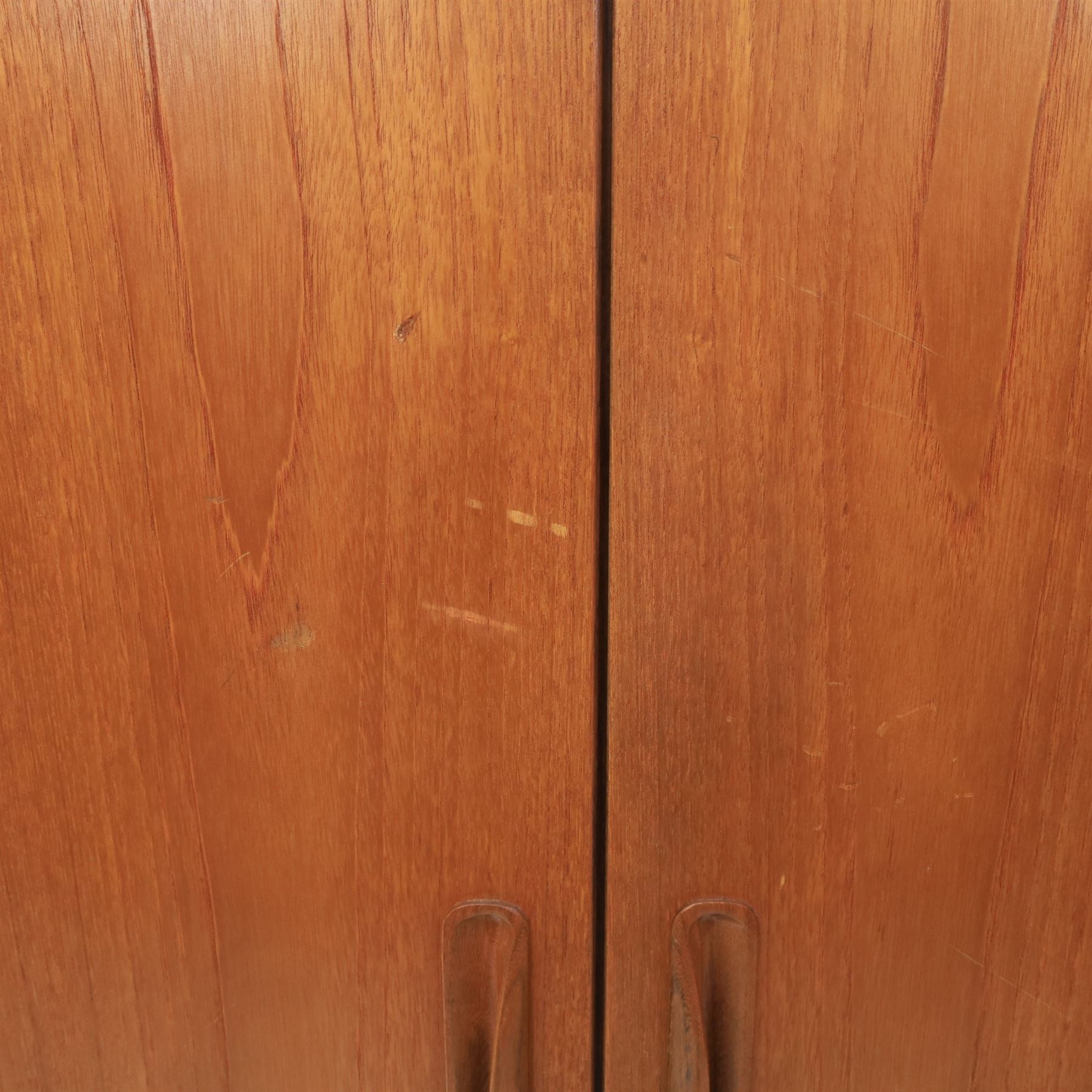 G Plan - 'Fresco' teak double wardrobe, twin doors enclosing a single clothes rail, on a recessed plinth base with castors beneath  