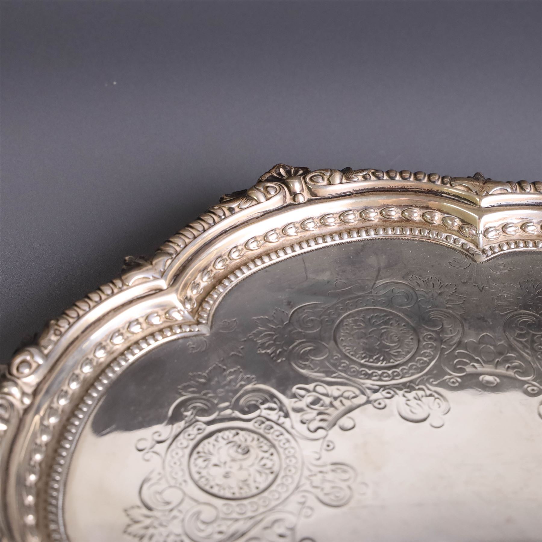 Late Victorian silver salver, of lobed circular form, with foliate beaded rim and engraved floral decoration to centre, upon three claw and ball feet, hallmarked Martin, Hall & Co Sheffield 1896, D26cm