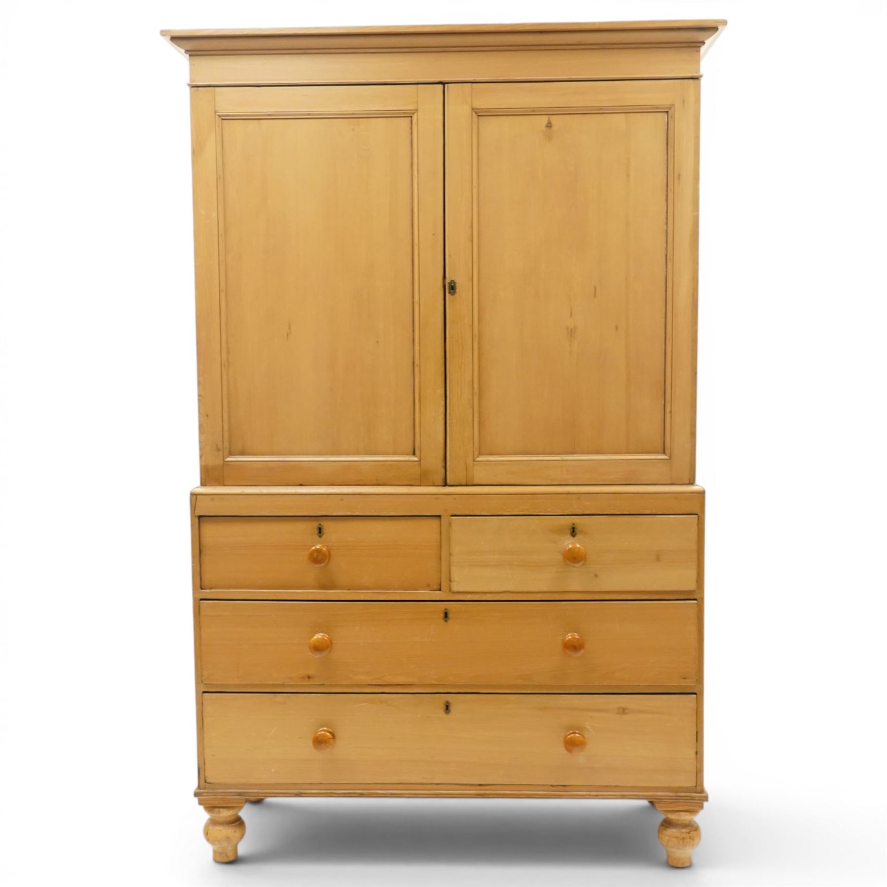 Victorian stripped pine housekeepers cupboard, projecting cornice over two panelled cupboard doors enclosing two shelves, the base fitted with two short over two long graduating drawers, lower moulded edge over turned feet