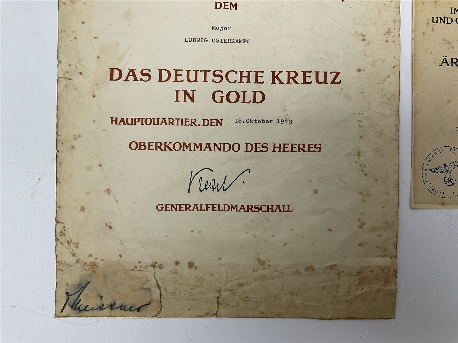 Three German documents dated 1942 - Gold Cross award to Major Ludwig Osterkampf; and Crete wound certificate and cuff title certificate awarded to Feldwebel Alfred Glaise; all unframed (3)